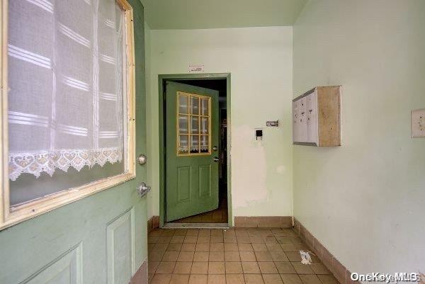 doorway to outside with light tile patterned flooring