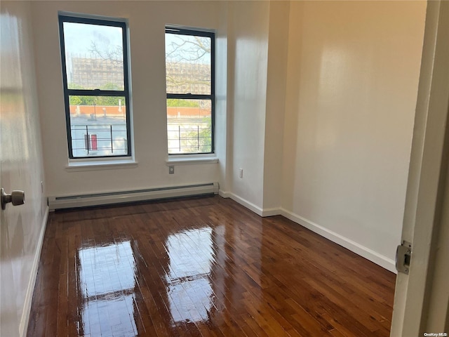 spare room with dark hardwood / wood-style floors and baseboard heating