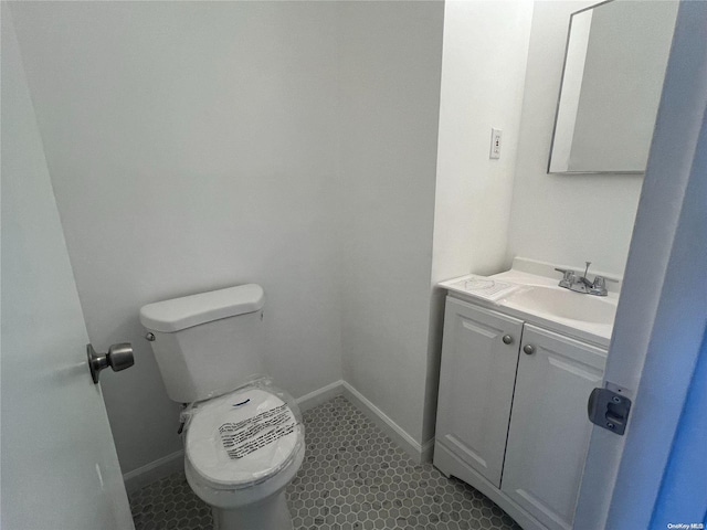 bathroom with tile patterned flooring, vanity, and toilet