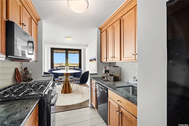 kitchen with black appliances, decorative backsplash, sink, and dark stone counters