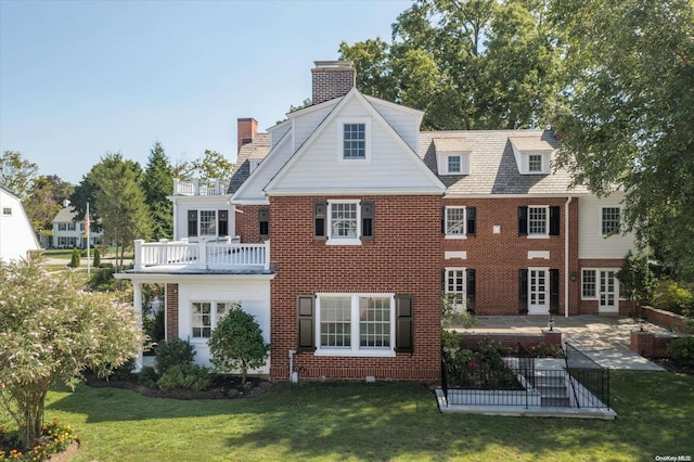 back of house with a patio area, a balcony, and a yard