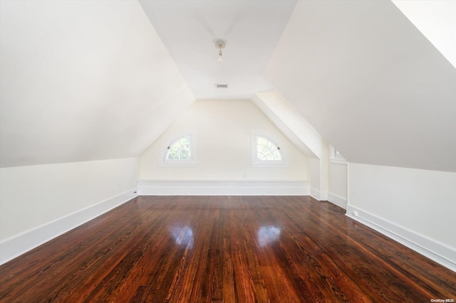 additional living space featuring lofted ceiling and dark wood-type flooring