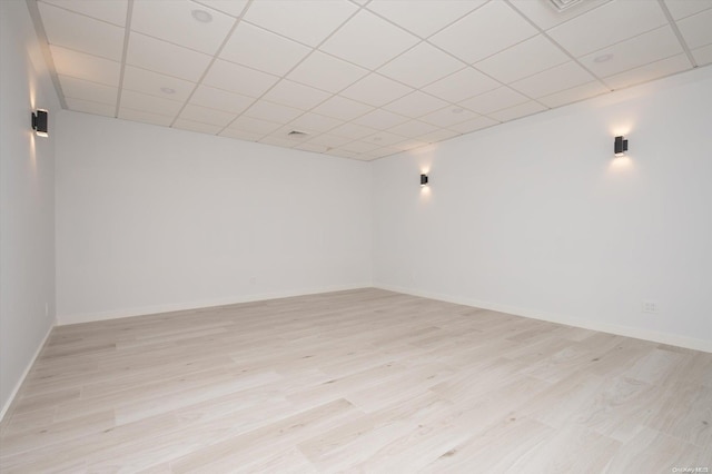 empty room featuring light hardwood / wood-style floors and a drop ceiling