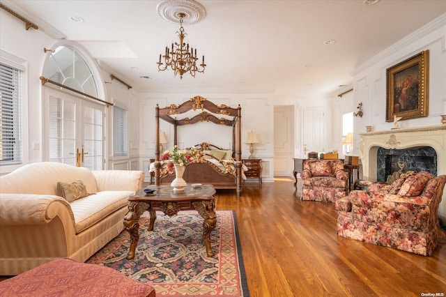 bedroom with wood-type flooring, ornamental molding, a chandelier, and french doors