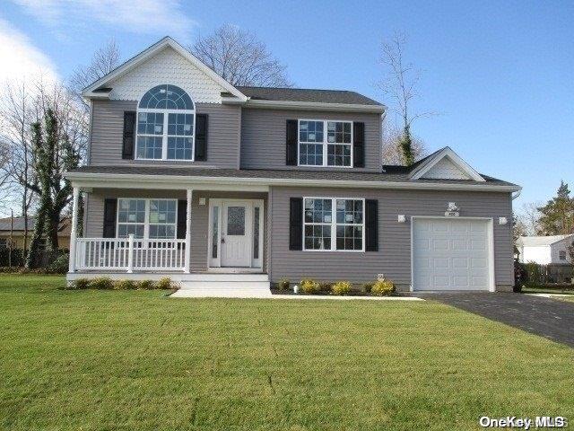 front of property with covered porch, a garage, and a front lawn