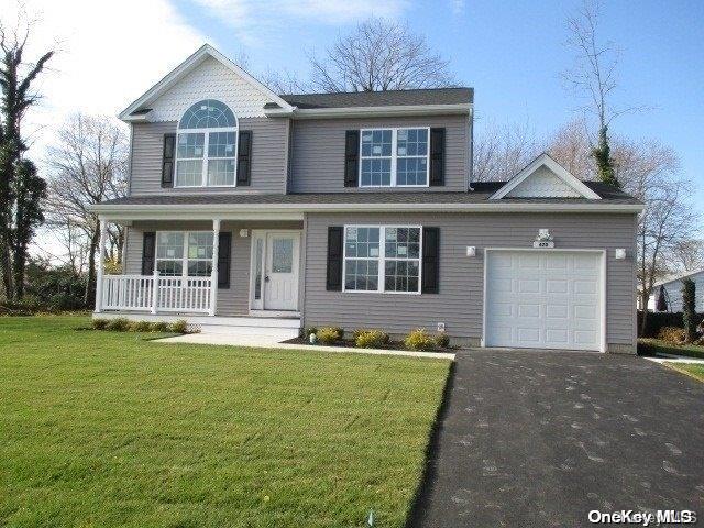 front of property featuring a front yard, a porch, and a garage