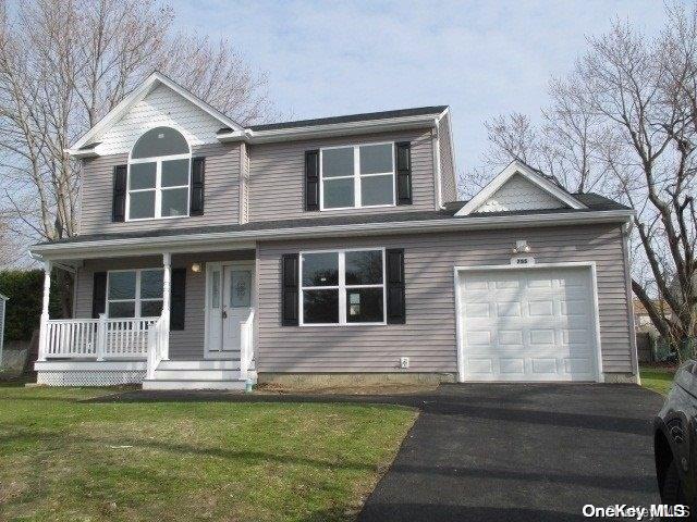 view of front property featuring a porch, a garage, and a front lawn