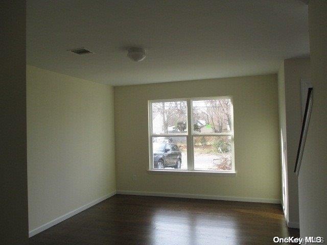 empty room with dark hardwood / wood-style floors