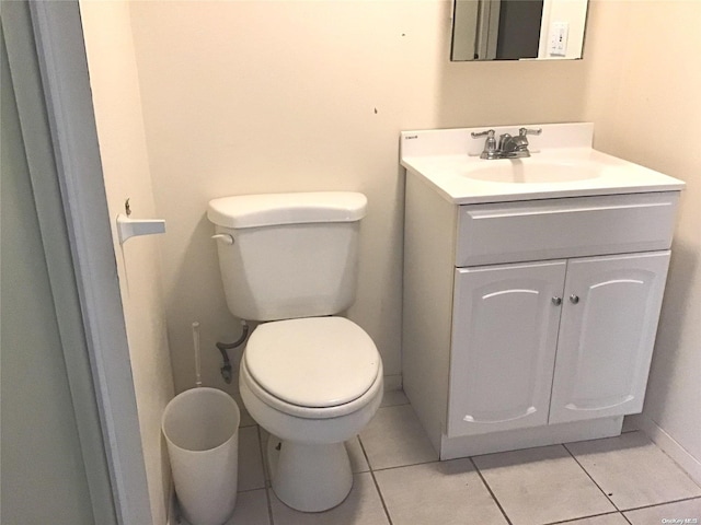 bathroom with toilet, vanity, and tile patterned floors