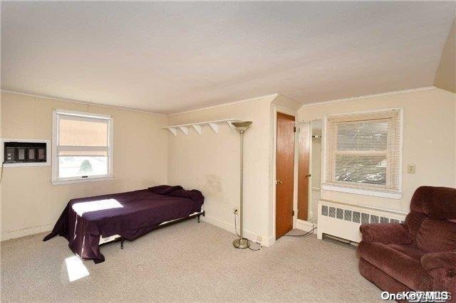 carpeted bedroom featuring radiator and lofted ceiling