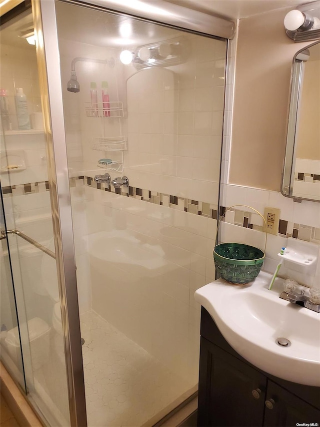 bathroom featuring backsplash, vanity, and walk in shower