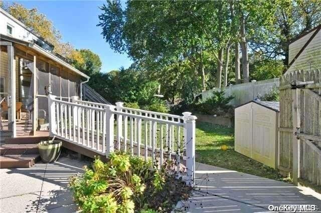 exterior space with a deck, a storage shed, and a sunroom