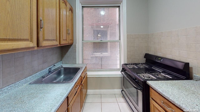 1075 Grand Concourse Unit 3C, Bronx, NY 10452 - kitchen featuring gas stove, a sink, light tile patterned floors, baseboards, and backsplash