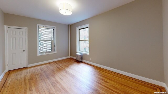 1075 Grand Concourse Unit 3C, Bronx, NY 10452 - spare room with radiator, light wood-type flooring, and baseboards