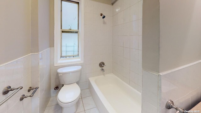 bathroom featuring tiled shower / bath, toilet, tile walls, and tile patterned floors