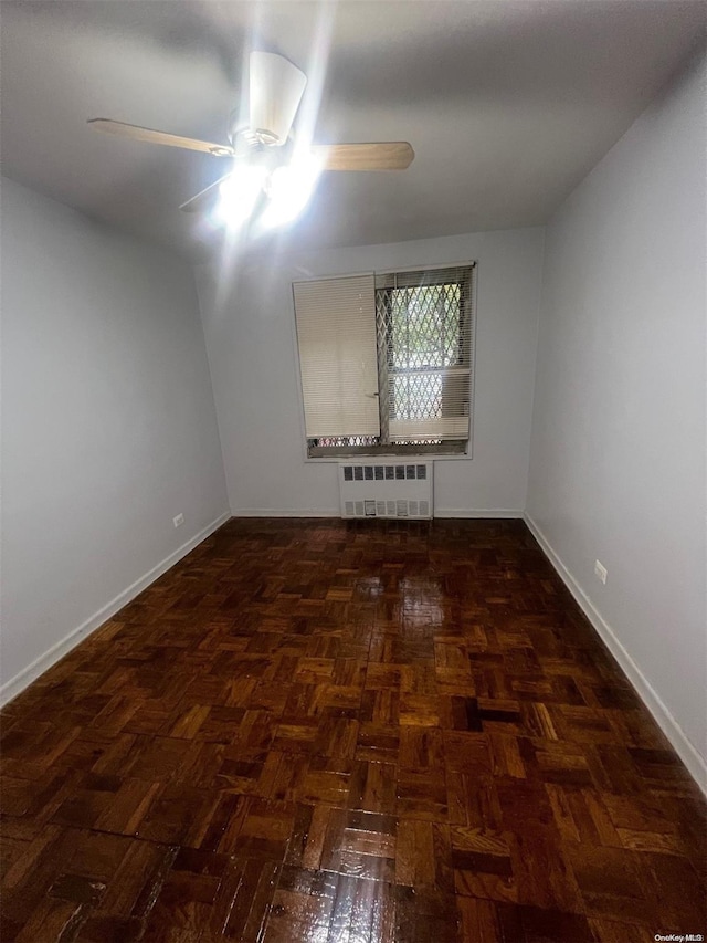 unfurnished room with radiator heating unit and ceiling fan