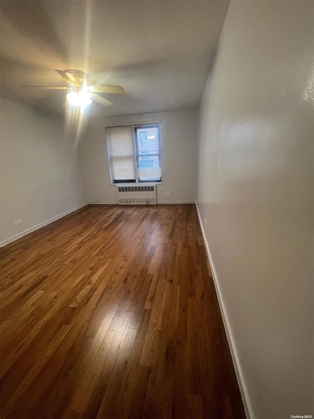 bonus room featuring dark hardwood / wood-style flooring, ceiling fan, and radiator heating unit