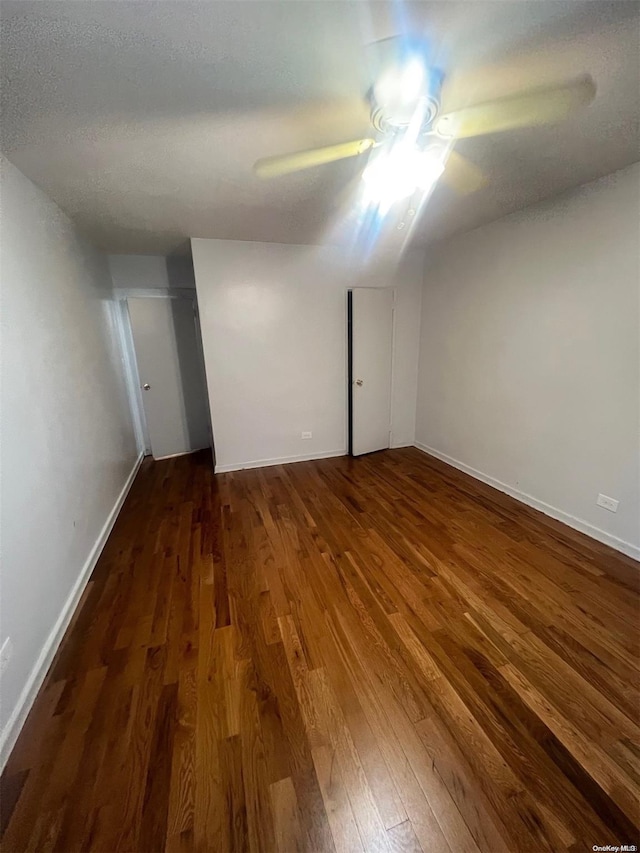 interior space with ceiling fan, dark wood-type flooring, and a textured ceiling