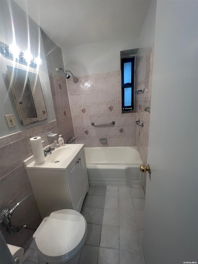 full bathroom featuring tile patterned floors, vanity, tile walls, toilet, and tiled shower / bath