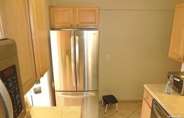 kitchen featuring light brown cabinets, light tile patterned floors, and appliances with stainless steel finishes