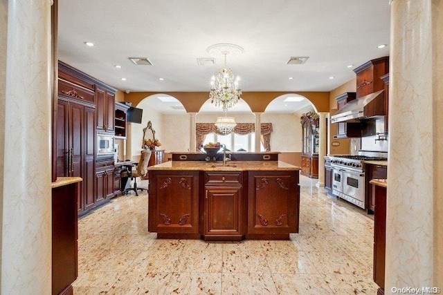 kitchen featuring sink, hanging light fixtures, wall chimney range hood, a chandelier, and range with two ovens