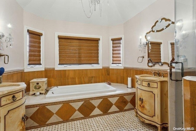 bathroom featuring tiled bath and vanity