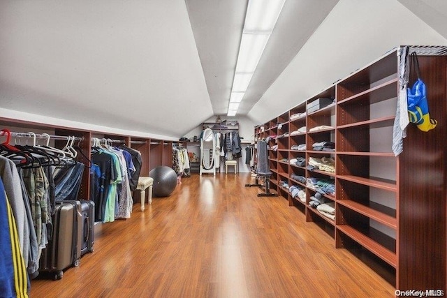 walk in closet featuring wood-type flooring and vaulted ceiling