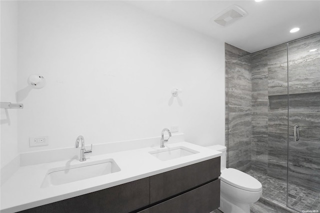 bathroom featuring vanity, toilet, and a shower with shower door