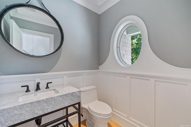 bathroom with crown molding, vanity, and toilet