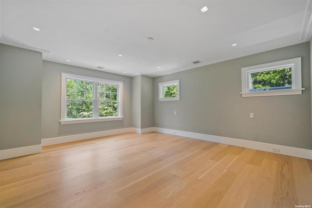 spare room featuring crown molding and light hardwood / wood-style flooring