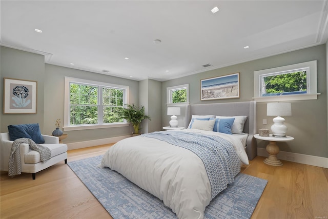 bedroom with crown molding and light hardwood / wood-style flooring