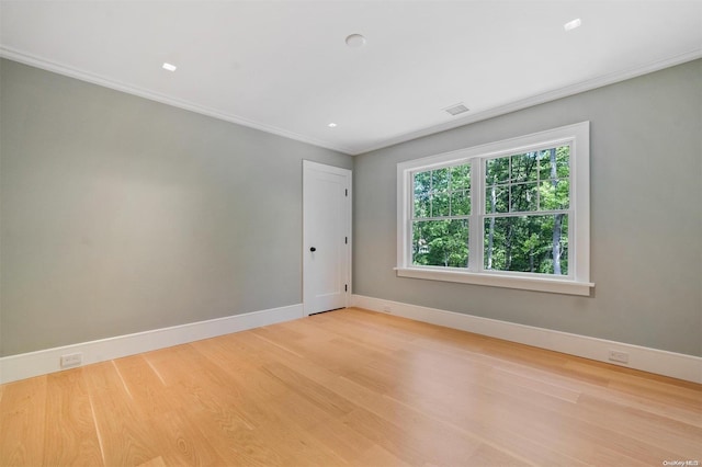 unfurnished room featuring ornamental molding and light hardwood / wood-style floors