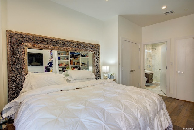 bedroom with hardwood / wood-style flooring, ensuite bathroom, and a closet