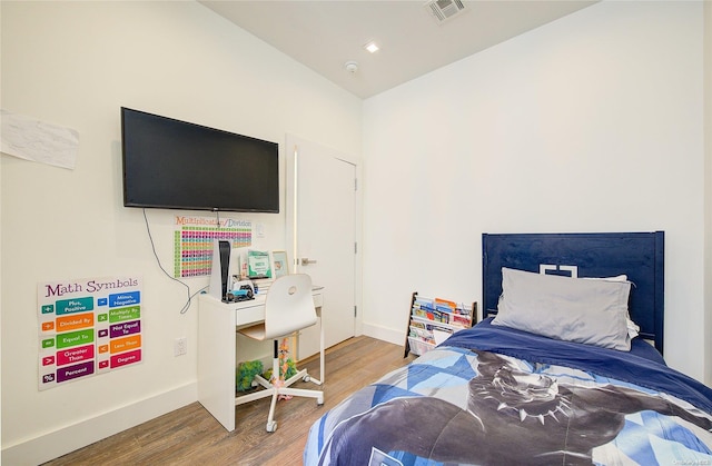 bedroom with lofted ceiling and hardwood / wood-style flooring