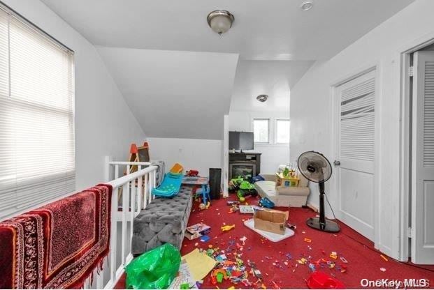 recreation room featuring carpet flooring and lofted ceiling