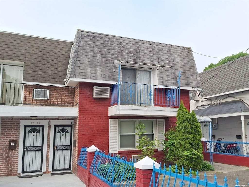 view of property featuring a balcony and a wall unit AC