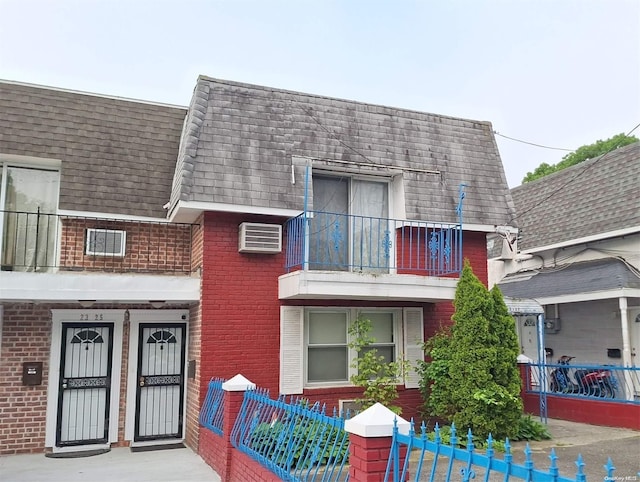 view of property featuring a balcony and a wall unit AC