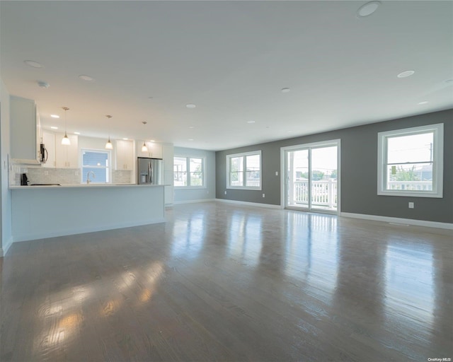 unfurnished living room featuring sink and dark wood-type flooring