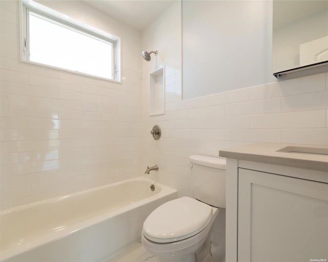 full bathroom featuring vanity, tiled shower / bath combo, tile walls, and toilet