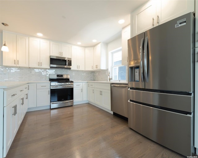 kitchen featuring pendant lighting, white cabinetry, stainless steel appliances, and dark wood-type flooring