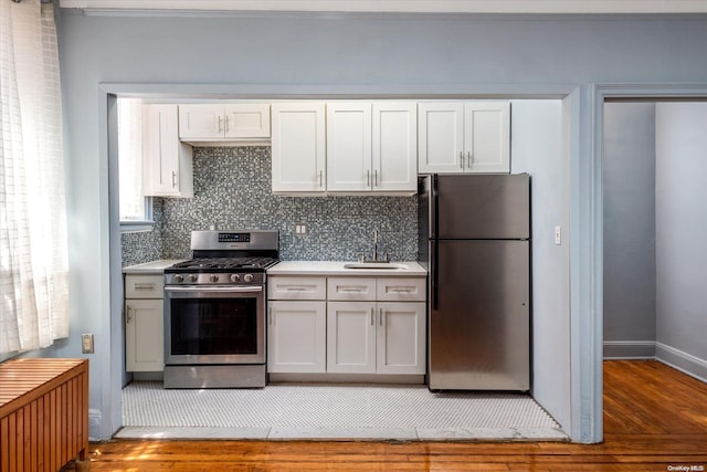 kitchen featuring white cabinets, appliances with stainless steel finishes, and hardwood / wood-style flooring