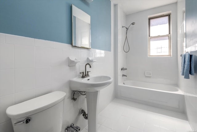 bathroom featuring tiled shower / bath, toilet, tile walls, and tile patterned floors