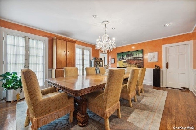 dining space featuring a chandelier, wood-type flooring, french doors, and ornamental molding