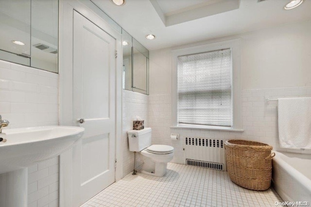 bathroom with tile patterned flooring, radiator heating unit, toilet, and tile walls