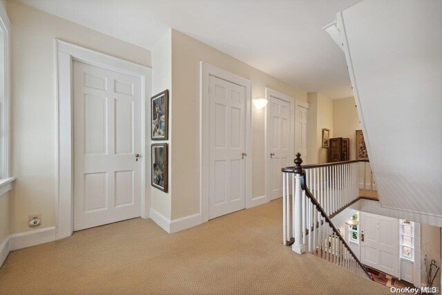 203 Albon Rd, Hewlett Harbor, NY 11557 - hallway featuring an upstairs landing, light colored carpet, and baseboards