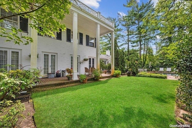 back of house featuring a lawn and french doors