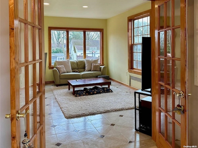 interior space with a healthy amount of sunlight, radiator, and french doors