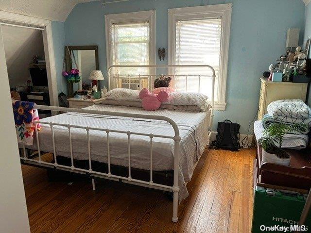 bedroom with lofted ceiling and hardwood / wood-style flooring