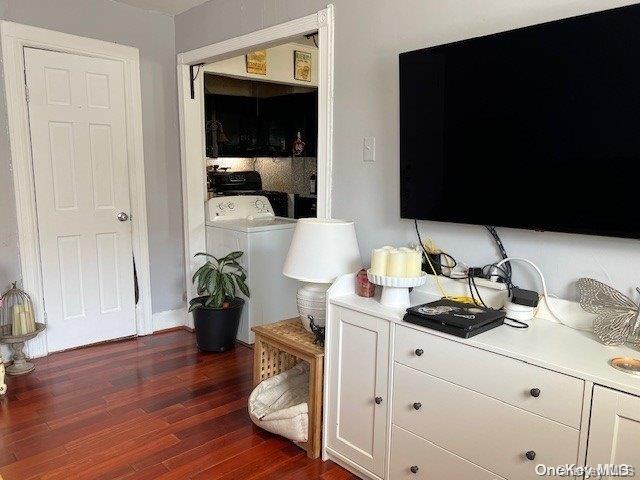 interior space with washer / dryer, dark hardwood / wood-style floors, and white cabinetry