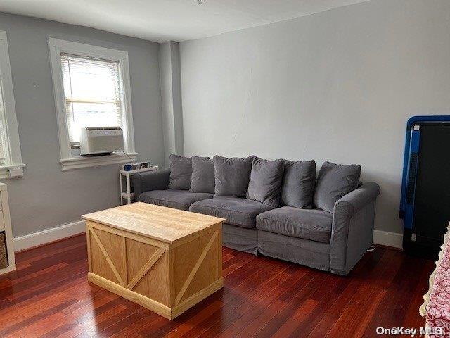 living room featuring cooling unit and dark wood-type flooring